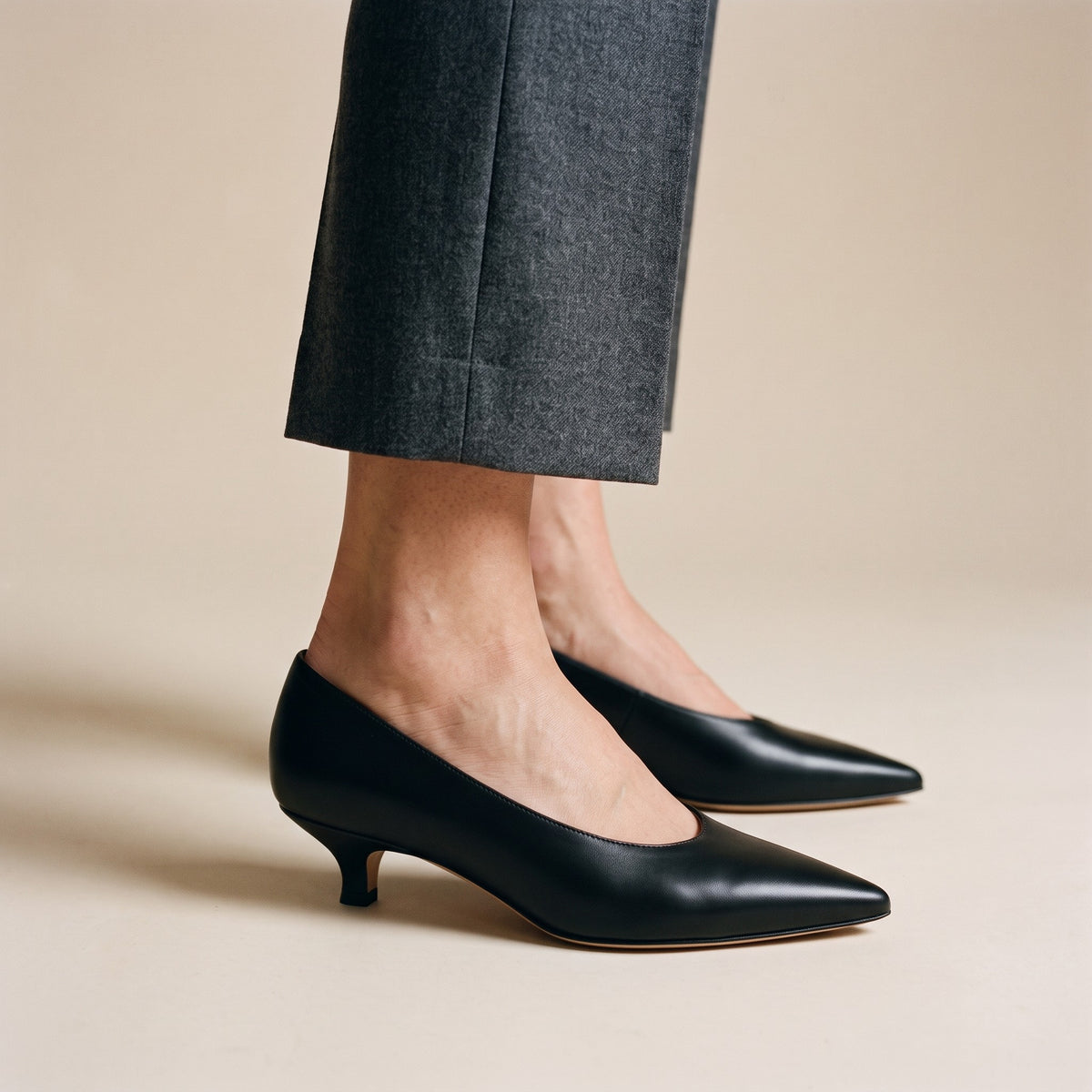 Décolleté Isabella Ferrante Petraio in nappa nera indossata con pantalone grigio, tacco kitten basso da 35 mm e punta sfilata, look da ufficio.